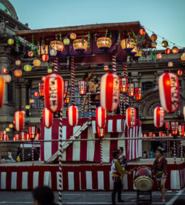 TOKYO, JAPAN - AUGUST 10 2012: Paper lanterns and the stage of the Tsukiji Honganji Bon Odori Matsuri - the popular festival in Tokyo. Text on the lanterns are names of the festival sponsors.