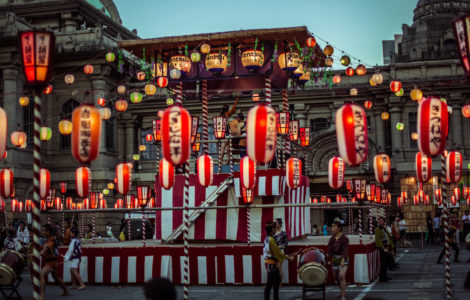 TOKYO, JAPAN - AUGUST 10 2012: Paper lanterns and the stage of the Tsukiji Honganji Bon Odori Matsuri - the popular festival in Tokyo. Text on the lanterns are names of the festival sponsors.