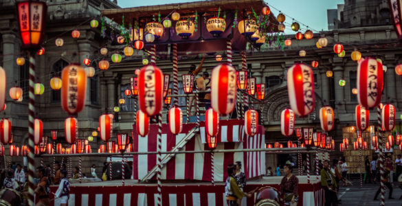 TOKYO, JAPAN - AUGUST 10 2012: Paper lanterns and the stage of the Tsukiji Honganji Bon Odori Matsuri - the popular festival in Tokyo. Text on the lanterns are names of the festival sponsors.