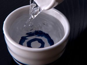 Sake pouring into an ochoko from a tokkuri