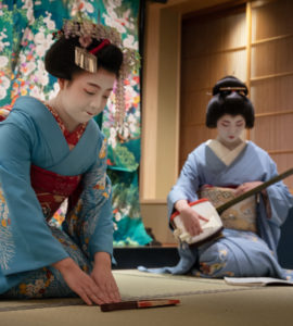 Kyoto, Japan - May 19, 2019: Maiko bows at the end of traditional performance in a small Japanese inn with geisha behind