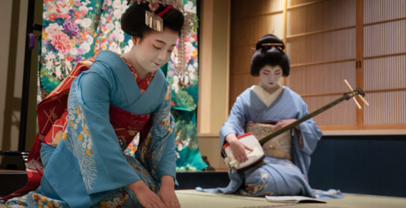 Kyoto, Japan - May 19, 2019: Maiko bows at the end of traditional performance in a small Japanese inn with geisha behind