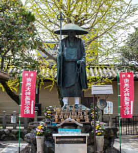 Kyoto, JAPAN - Apr 2 2021: The statue of Japanese Buddhist monk Kobo Daishi Kukai in To-ji (Toji Temple) complex on a sunny day. Translation: Namu-daishi-henjou-kongo (convert to Henjou-kongo Daishi)